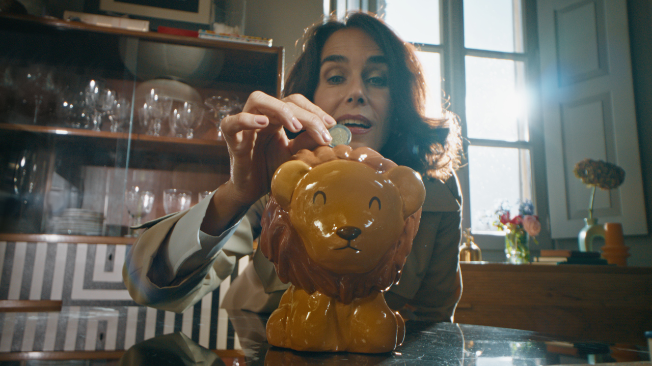 donna inserisce moneta di due euro nel salvadanaio di ing