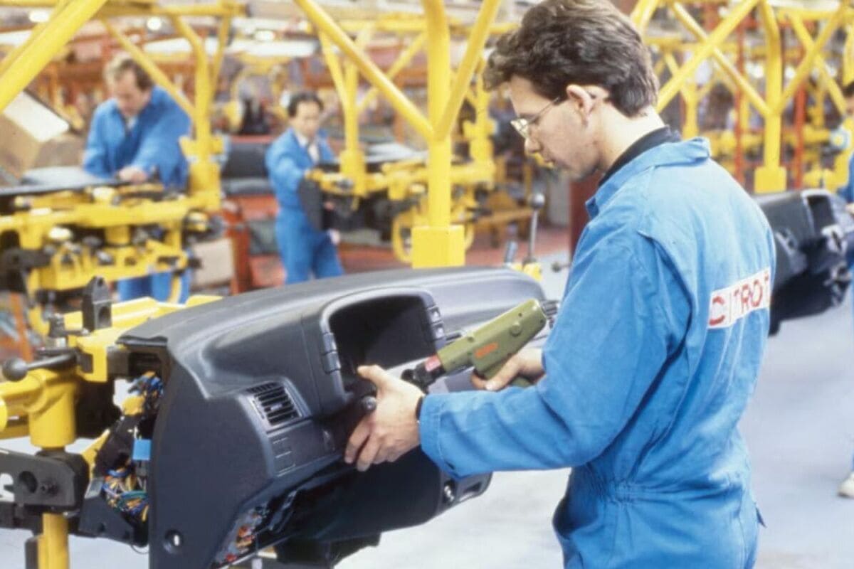 Operai al lavoro su una catena di montaggio Stellantis in Francia, simbolo della crisi dell'industria automobilistica europea