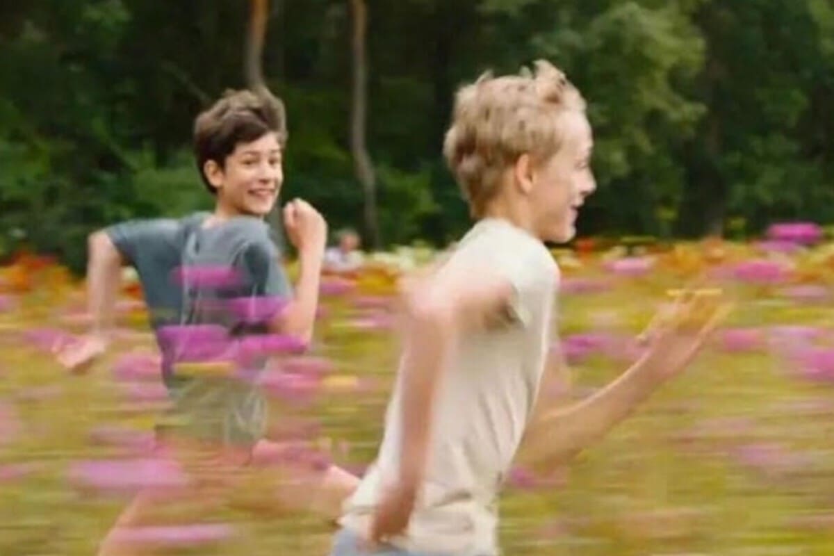 Eden Dambrine e Gustav De Waele in una scena del film mentre corrono in un prato fiorito