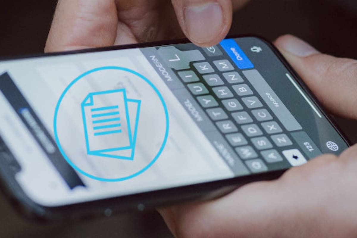 Mano che incolla un testo sullo smartphone dopo averlo copiato dal computer