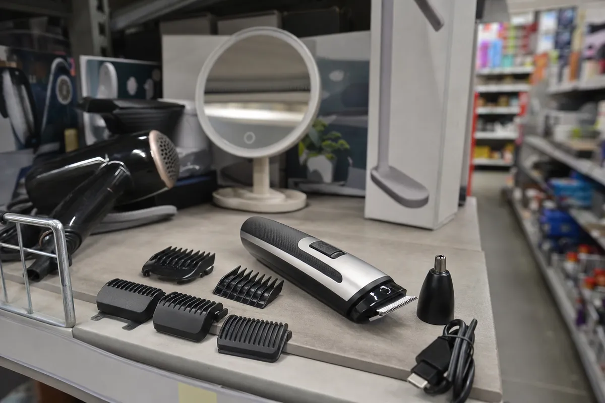 Kit di regolabarba elettrico con pettini intercambiabili e accessorio naso, su banco in corsia supermercato
